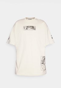 Cream-colored oversized t-shirt made of cotton, featuring black graphics of a character and detailed designs on the front and sleeve.