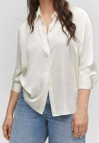 White button-up shirt with long, roll-up sleeves made of soft, lightweight fabric, featuring a relaxed fit and subtle sheen.