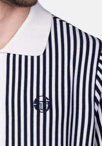 Gestreiftes Poloshirt in Marineblau und Weiß, aus gestricktem Stoff gefertigt. Verfügt über einen weißen Kragen und ein gesticktes Logo auf der Brust.