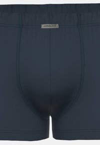 Mörkblå boxerbriefs gjorda av mjukt tyg, med en formad påse, kontrasterande sömmar och en silverfärgad logotags på midjebandet.