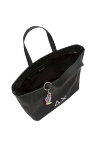 Borsa tote nera realizzata in materiale morbido con due manici, caratterizzata da un logo geometrico bianco e un charm colorato attaccato. Design con apertura superiore.