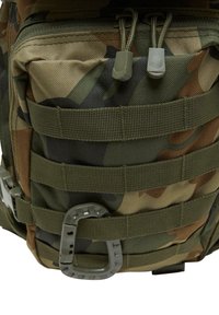 Camouflage backpack, textured fabric, features multiple webbing straps and a gray carabiner, with a zippered compartment at the top.