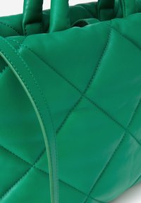 Groene leren handtas met een gequiltde textuur, voorzien van verticale stiksels en twee handvatten. Gladde afwerking met accenten in dezelfde kleur.