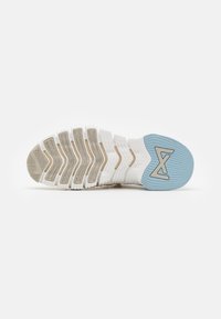 Semelle de chaussure avec des motifs de bande de roulement blancs et beiges, avec une section de talon bleu clair avec un logo géométrique sur fond blanc.