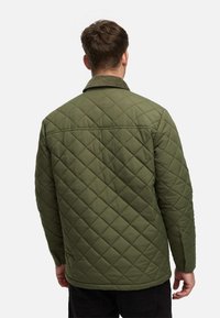 Grüne, gesteppte Jacke mit Kragen, die ein Rautenmuster aufweist, im lässigen Schnitt und mit einer glatten, matten Oberfläche gestaltet.