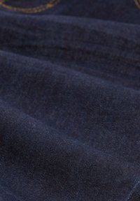 Dunkelblauer Denim-Stoff mit einer glatten Textur, der subtile Farbvariationen und ein sichtbares Nähmuster aufweist.