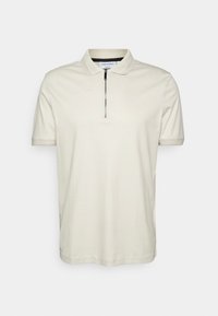 Crème kleurige polo shirt gemaakt van zacht materiaal, met een ritskraag en korte mouwen. Het ontwerp is eenvoudig en klassiek.