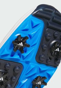 Suola di una scarpa sportiva con suola esterna in plastica blu con motivi triangolari, punte nere e dettagli testurizzati per una migliore aderenza.