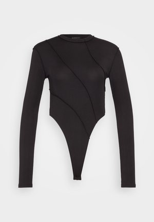 Zwarte lange mouwen bodysuit met een hoge hals, met een asymmetrisch ontwerp en geribbeld textuur. Uitsnijding bij de taille.