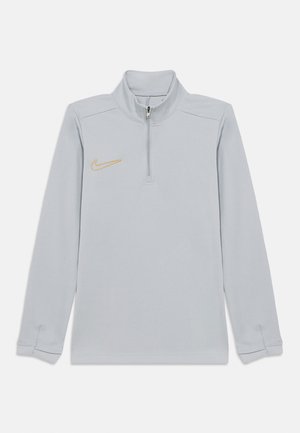 Maglia sportiva con zip color grigio chiaro, maniche lunghe, collo alto e piccolo logo Nike dorato sul petto sinistro.