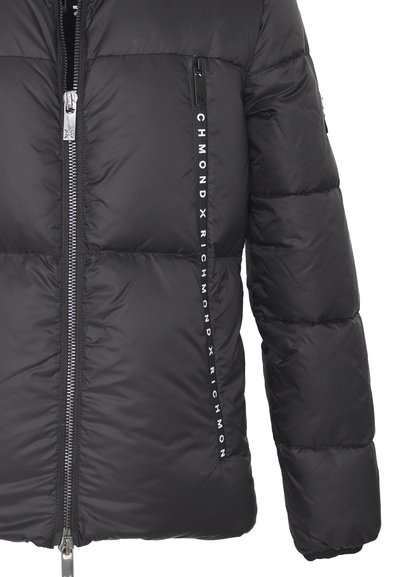 Giacca a vento nera con chiusura a zip, caratterizzata da una finitura lucida, texture trapuntata e logo bianco sui lati lungo la cerniera.