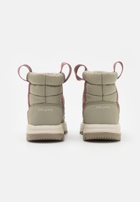 Botas ligeras con un upper acolchado verde, acentos rosas y tiradores. Cuentan con una suela beige con la marca "200 gramos" y "TECHLITE".