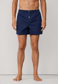 Mornarsko plave kupaće gaće s elastičnim pojasom, kopčanjem na dugme sprijeda i jednostavnim dizajnom. Lagani materijal i klasičan kroj.