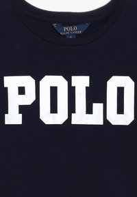 Marineblauwe katoenen t-shirt met witte tekst "POLO" in vetgedrukte, blokletters; ronde halslijn; label toont "RALPH LAUREN" en maat M.