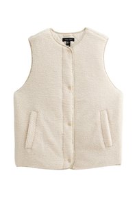 Krämfärgad, ärmlös väst gjord av mjukt, texturerat tyg. Har knäppning fram och två sidofickor. Ingen krage.