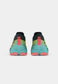 Scarpe da trail running nere, verdi e turchesi con parte superiore in rete testurizzata, colletto del tallone prominente e suola rosa con motivo di aderenza.