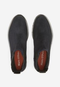 Bottines en suède bleu marine avec des panneaux latéraux élastiques et une semelle en caoutchouc. Possède une semelle intérieure rouge avec le logo "Marc O'Polo". Texture lisse.