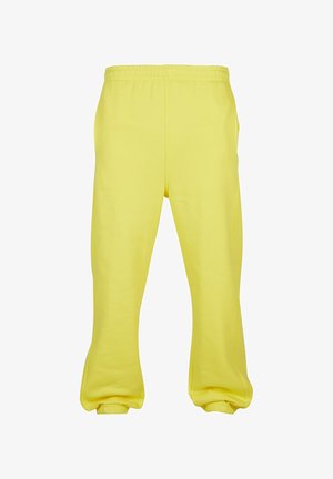 Kollased dressipüksid pehmest kangast, millel on elastne vöökoht, kitsenevad jalad ja elastsed mansetid pahkluude juures.