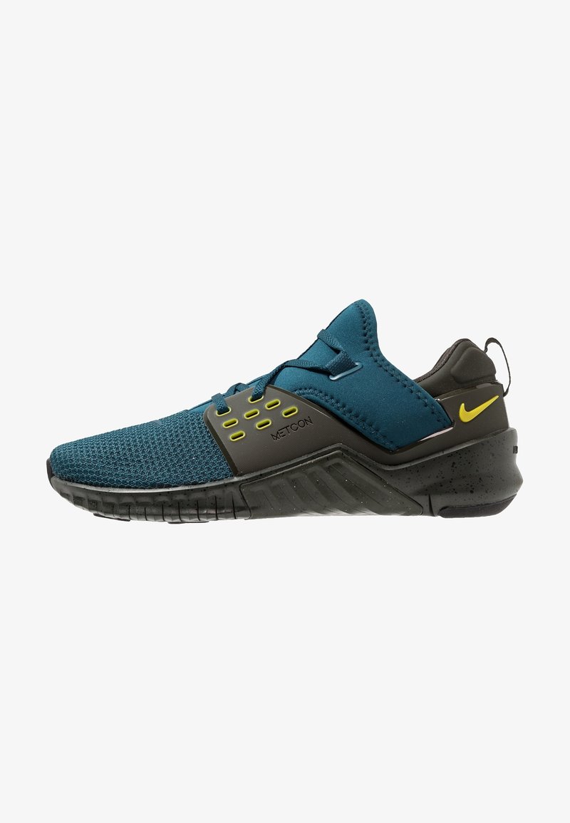 Chaussure Nike Metcon bleu sarcelle et noire avec accents jaunes, tige en mesh, talon rembourré et semelle robuste conçue pour l'entraînement et les séances de sport.