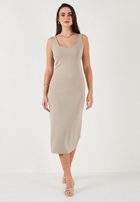 Abito midi beige senza maniche con scollo rotondo, realizzato in tessuto liscio, silhouette aderente e taglio dritto che arriva a metà polpaccio.