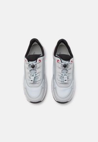 Light gray athletic shoes with mesh upper, rubber sole, adjustable lacing, and black accents. Features a textured surface and prominent logo.