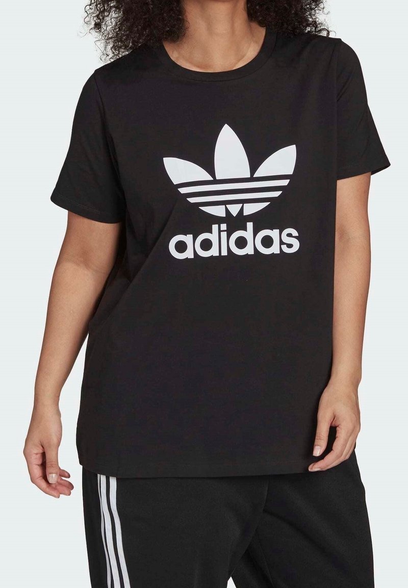 Černé bavlněné tričko s velkým bílým logem Adidas a třemi pruhy pod ním, krátké rukávy a volný střih.