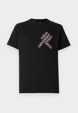 Zwarte katoenen T-shirt met een diagonale roze "calvin klein" logo-print op de voorkant. Korte mouwen en een ronde halslijn.