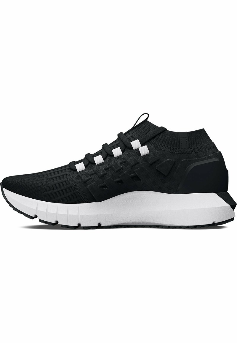 Zapatilla deportiva negra con parte superior de malla texturizada, cordones blancos y suela blanca gruesa. Presenta un collar acolchado y sutiles acentos geométricos.