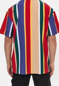 Camisa de manga corta multicolor con rayas verticales en rojo, verde, púrpura, amarillo y beige. Fabricada con suave tela de algodón.