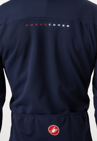 Tums zila krāsa garām piedurknēm velosipēdu džersija ar "ROSSO CORSA" logotipu baltā un sarkanā krāsā uz muguras, aprīkota ar aizmugurējo kabatu un gludu auduma tekstūru.
