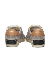 Sneaker in suede grigio con dettagli in pelle marrone, supporto al tallone nero, cuciture bianche e logo sul tallone. Suole in gomma piane.