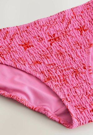 Roze zwemondergoed met een gestructureerd, geraffineerd ontwerp en rode accenten. Glad roze voering contrasteert met het buitenmateriaal.