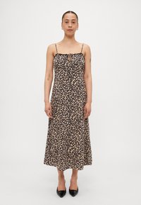 Robe midi imprimée léopard avec fines bretelles et décolleté froncé. Fabriquée en tissu léger, elle présente une coupe décontractée et un ourlet évasé. Talons noirs.