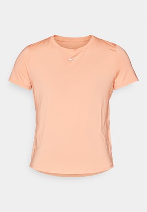 T-shirt Nike à manches courtes en pêche clair, fabriqué en tissu doux et respirant, avec un col rond et un petit logo blanc sur la poitrine.