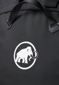 Black bag made of textured fabric, featuring a white circular logo with an elephant. Includes sturdy black handles.