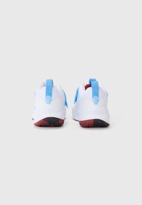 White athletic shoes with blue accents, featuring a mesh upper, pull tabs, and a red-black textured sole for traction.
