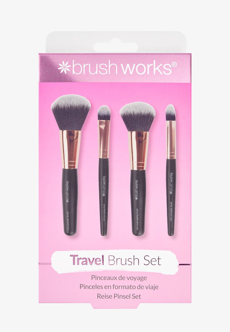 Juego de brochas de viaje que incluye cuatro brochas con mangos negros en punta, cerdas suaves en negro y gris, y un fondo de packagin rosa.