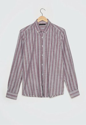 Langärmeliges Hemd mit Knöpfen, vertikalen weißen und schwarzen Streifen auf einem kastanienbraunen Hintergrund, hängend an einem Holzbügel.