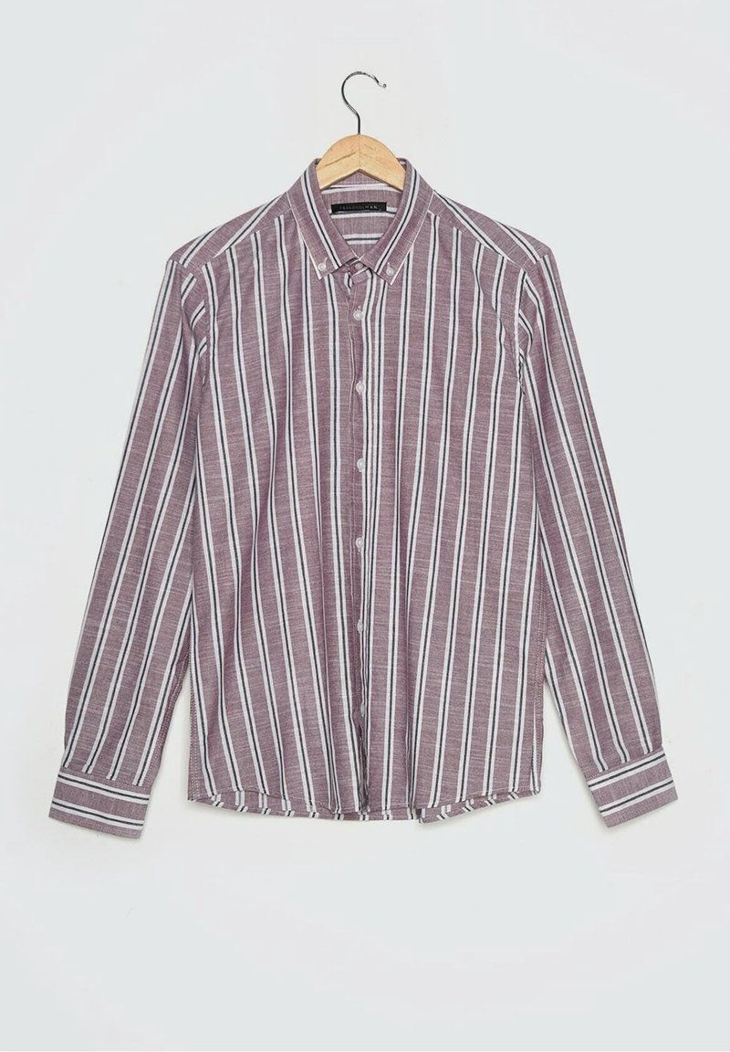 Chemise à manches longues à boutons avec des rayures verticales blanches et noires sur un fond bordeaux, suspendue à un cintre en bois.