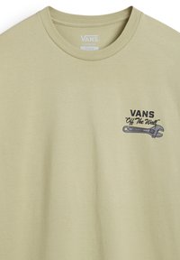 Camiseta de algodón verde claro con corte clásico; presenta un gráfico de una llave inglesa y el texto "VANS Off The Wall" en el lado izquierdo del pecho.