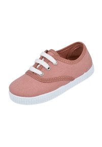 Zapato de lona en color melocotón suave, diseño con cordones y cordones blancos, con costuras decorativas y suela de goma texturizada.