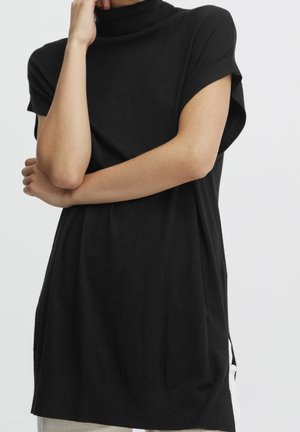 Tunic nera a maniche corte con colletto alto e vestibilità rilassata. Tessuto morbido con colletto a costine. Spacchi laterali per facilitare i movimenti.