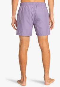Pantaloni da bagno viola con vita elasticizzata e un tessuto morbido e leggero. I pantaloni hanno una vestibilità dritta e un design semplice.