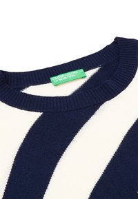 Námořnický a bílý pruhovaný svetr s kulatým výstřihem. Vyrobeno z pletené tkaniny s ribbed límcem a etiketou United Colors of Benetton.