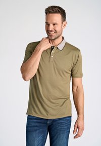 Olivgrön polotröja med en ljusgrå krage, treknappslå, korta ärmar och slät textur, tillsammans med blå denim jeans.