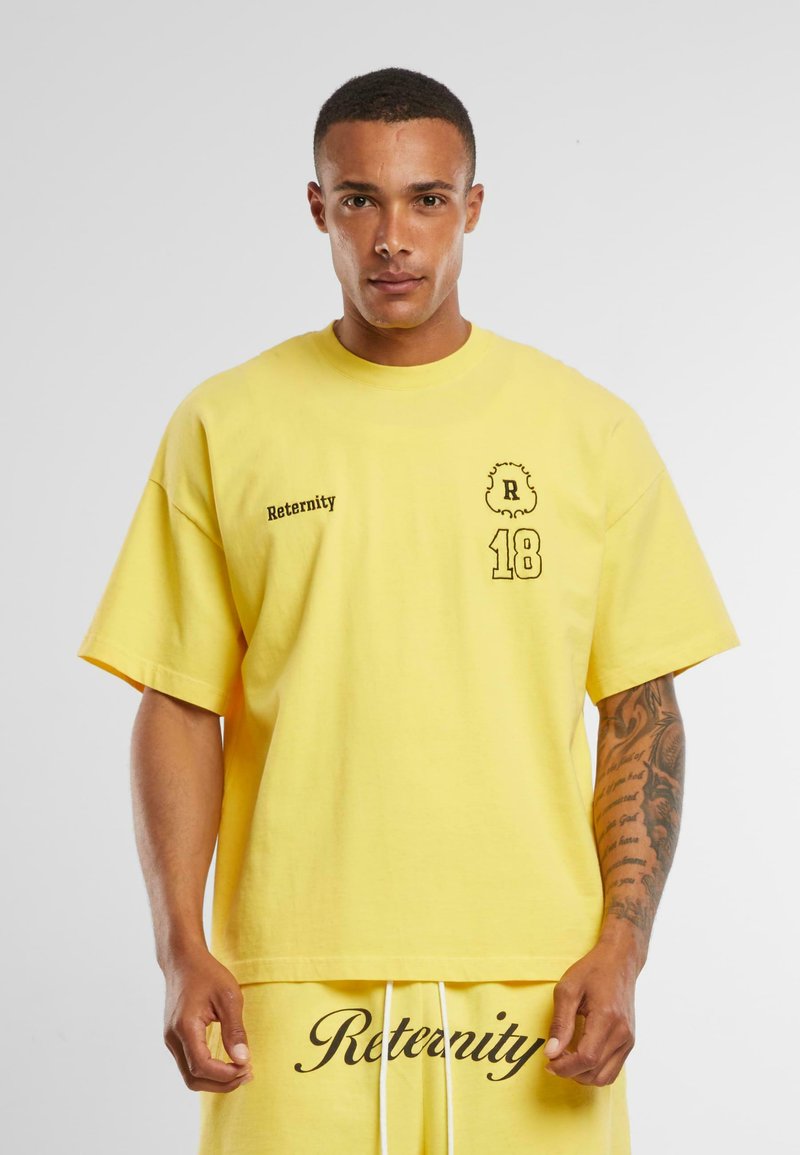 Yellow cotton oversized t-shirt featuring black text "Reternity" and a graphic "R 18" on the front. Short sleeves and relaxed fit.
