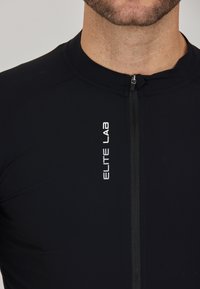 Schwarzes Fahrradtrikot aus elastischem Material, mit einem Reißverschluss auf der Vorderseite, kurzen Ärmeln und dem "ELITE LAB"-Logo in Weiß auf der Brust.