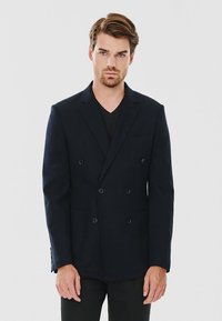 Granatowy dwurzędowy żakiet z klapami, stworzony z teksturowanej tkaniny, z dwiema przednimi kieszeniami i czterema guzikami dekoracyjnymi.