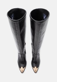 Botas de cuero negro hasta la rodilla con punta afilada y adornos dorados en la punta. Presentan detalles acampanados y un acabado elegante.