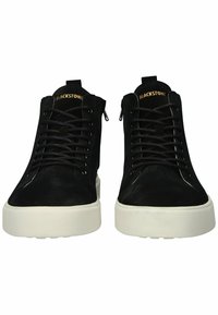 Černé vysoké tenisky vyrobené z semiše s bílou gumovou podrážkou a černými tkaničkami, vybavené zipovým uzavíráním a embosovaným logem na jazyku.